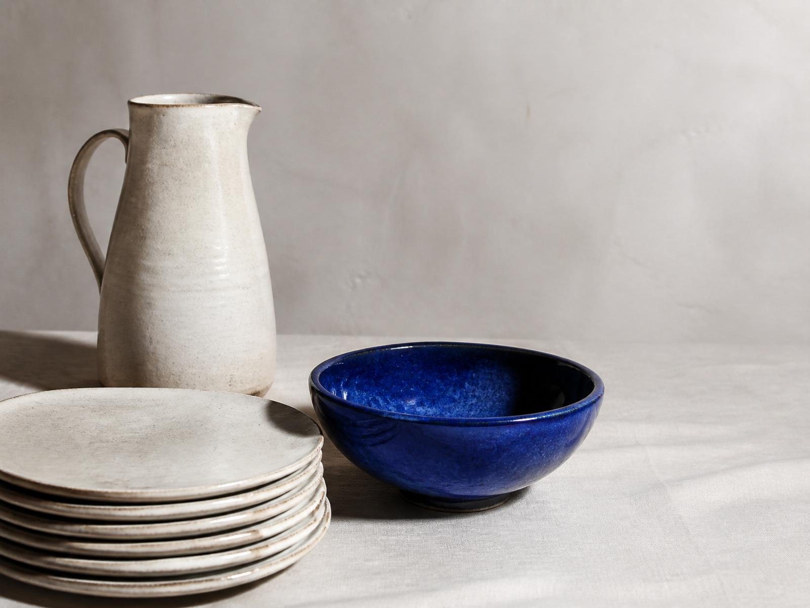 Composição de louça CS Ceramics — jarra em cerúsea, taça em azul cobalto e pratos em marfim